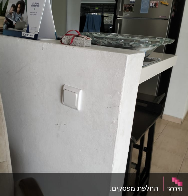 מתג חשמל על קיר לבן ליד מטבח